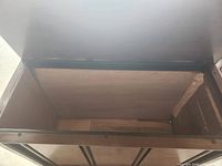 Cabinet interior with hinged top open showing clean wooden compartment