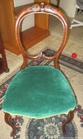 Full view of carved balloon back chair with green velvet seat