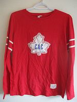 Full front view of red long-sleeve jersey on hanger