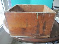 Exterior front view of rectangular wooden tool box showing wear and paint drips