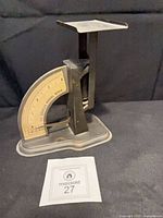 Side view of metal Superior postal scale on base