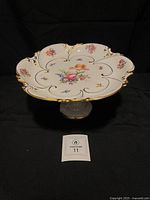 Side view of porcelain pedestal bowl showing pedestal foot and floral decorated top