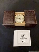 Clock in open sliding faux leather case with MaxSold placard