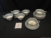 All six teacups and seven saucers displayed on black background