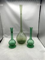 Three green glass vases displayed together