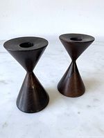 Front view of both rosewood candlesticks on marble surface