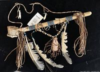Full view of antler peace pipe showing bowl, bead-wrapped stem, fringe, feathers, bead drop