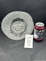 Top view of clear textured glass bowl beside soda can for scale