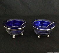 two sterling salt cellars with cobalt liners and spoons