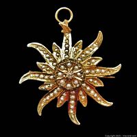 Front view of gold starburst brooch showing seed pearls and center diamond