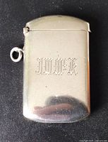 Front of sterling silver vesta showing monogram and hinged lid