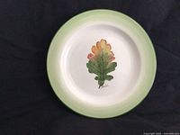 Front view showing painted oak leaf and green rim