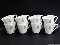Eight white mugs stacked, showing crest fronts