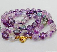 Coiled fluorite bead necklace showing bead colours and clasp