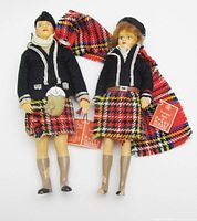 Front view of both Peggy Nisbet Scottish dolls with hang tags visible
