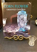 Front cover of book on stand with etched shot glass