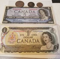 Group shot of both banknotes and three coins