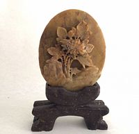 Front view of carved soapstone plaque on stand