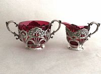 Both cranberry glass pieces in silver-plate frames, front view