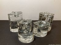 Five clear glass Iittala Arkipelago candle holders grouped together
