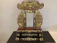 Full view of carved wood altar showing overall form, colors and gilt dragon motif