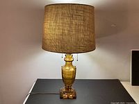 Full view of amber glass table lamp with shade