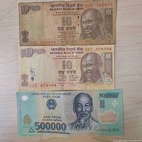 Fronts of two Indian 10-rupee notes and one Vietnamese 500,000-đồng note