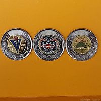 Obverse sides of three coloured Canadian $2 coins showing commemorative designs