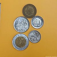 Obverses of five world coins on yellow background