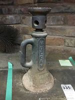 Front side view of the Vulcan cast iron screw jack showing handle, embossed brand name, and base with dirt and some corrosion.