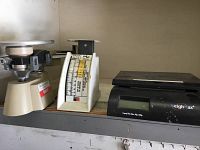 Three different scales on a shelf including Weighmax digital scale, Ohaus balance scale, and Recipe Scale Model 1308 showing full lot content