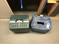 Two items: green EIKI 16mm film projector and blue EIKI SOUND carrying case.