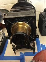 Front view of stereopticon showing McIntosh name and brass lens with black cover.