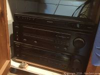 Front view of stacked Magnavox DVD player, Kenwood stereo receiver, and Kenwood cassette deck showing all three electronic components together