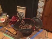 Various angles of the collection showing boot jack, coal bucket with pine cones, washboard, iron hand pump, and candle with sconce in front of a fireplace.