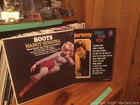 Boots by Nancy Sinatra and Sing for You by Jeremy placed in front of shelf