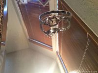 Full wristwatch showing front and part of the wrist bracelet on a reflective surface.