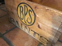 Wooden box marked BPS PAINTS, used for storage of train set items.