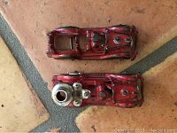 Both vintage red Hubley fire trucks displayed on tiled floor, showing top and side views