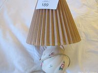 Lamp with lot tag showing pleated shade and floral base