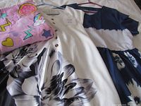 Group shot of three dresses and pink towel bag