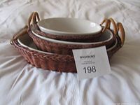 view of nested ceramic dishes inside baskets with lot tag