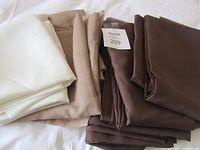 Stacks of white, beige and brown folded curtain panels