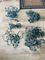 All five tangled Christmas light sets laid out on floor