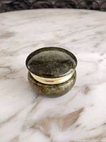 Closed round green stone trinket box showing polished surface