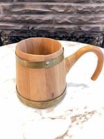 Frontal view of wooden tankard showing brass-tone bands and handle