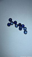 All ten round blue sapphires displayed on white background