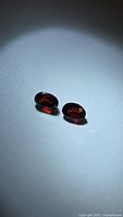 Pair of oval red garnets on neutral background