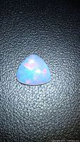 Front view of triangular fire opal showing play-of-colour