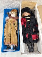 Both boxed porcelain dolls side by side